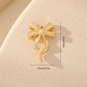 Macro view of gold bow pendant with zircon inlay showing 1.9x2.0cm dimensions