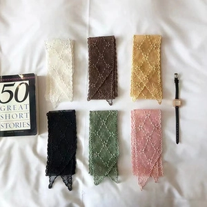 Flat lay of lace hairbands with lattice embroidery and scalloped edges in six colors