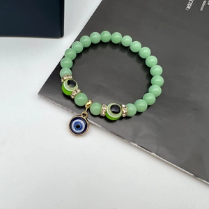 Green luminous beaded bracelet with Turkish evil eye charms and golden spacers