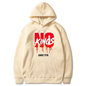 Close-up of cream hoodie with No Kings Since 1776 graphic print and front pocket detail