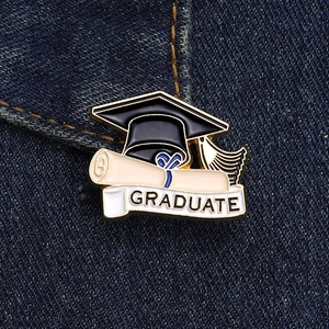 Macro view of graduation cap enamel pin with scroll on blue denim fabric