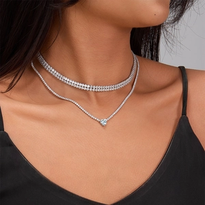 Model wearing a double-layer silver necklace with a blue heart-shaped zircon pendant