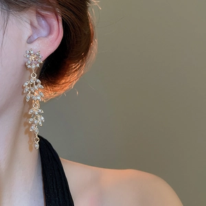 Gros plan de boucles d'oreilles élégantes à franges en or avec diamants blancs de luxe