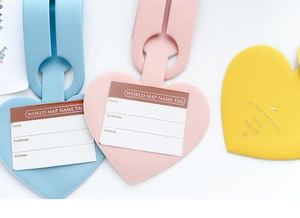 Macro detail of heart-shaped faux leather luggage tags with refined cross-grain texture