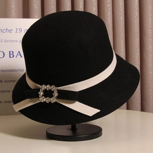 Détail de chapeau cloche en laine avec ruban ivoire et boucle ornée de cristaux brillants