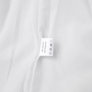 Detailaufnahme des Textiletiketts mit 50% Viskose und 50% Polyester auf weißem Kleid