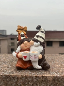 Detail of couple resin coffee gnomes with Coffee cups for rustic home tabletop decor