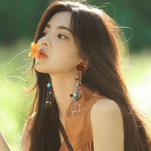 Bohemian dangle earrings with wooden beads and colorful stone tassels on female model