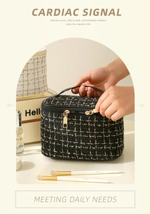 Detail showing high-quality black and white tweed makeup bag with golden metal zippers