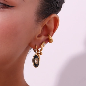 Close-up of 18K gold-plated irregular liquid earrings with black enamel and pearls