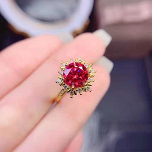 Macro shot of a 18k gold-plated sunflower ring with a 5-carat red corundum gemstone