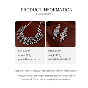 Detail of luxury green zircon water drop necklace and earrings set on silk background