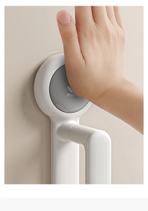 Close-up of white vacuum suction cup hook showing push-button mechanism on wall