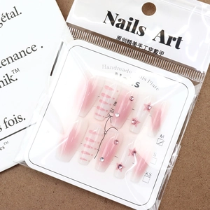 Pink blush gradient press-on nails with glitter stars and rhinestones in clear packaging