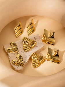 Detailed view of various 18K gold plated titanium steel earrings on a stone base