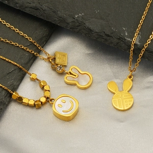 Three elegant 18k gold rabbit necklaces with shell pendants on premium silk background