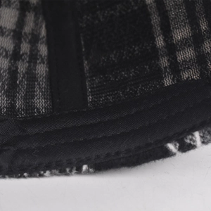 Macro shot of baseball cap interior showing black mesh and checkered fabric stitching