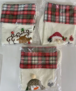Detailed view of Christmas stockings with Santa, reindeer, and penguin embroidery in plastic wrap