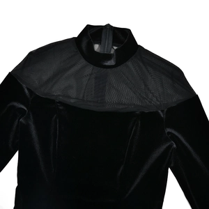 Dettaglio dell'abito in velluto nero a collo alto con inserto in rete e zip posteriore