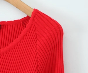Detailed close-up of the knitted lace neckline and ribbed texture on the red dress