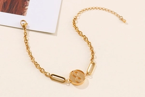 Detail eines goldenen Armbands mit Infinity-Symbol und verstellbarer Kette in Gold