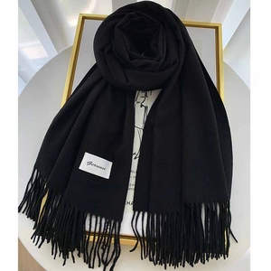Detail of soft black cashmere scarf with fringed edges and branded Gerunsi tag