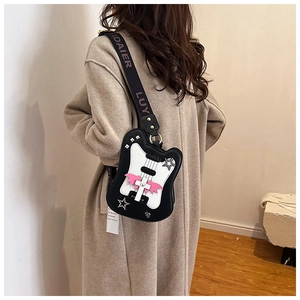 Detail of guitar shaped crossbody bag with pink wings and stars on a model