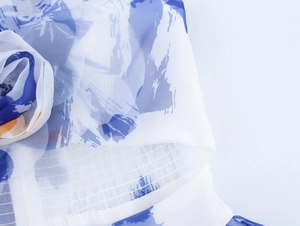 Detailansicht aus blauem Organza mit 3D-Blumenakzent und elastischer Smok-Verarbeitung