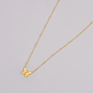 Detailed close-up of 18K gold plated butterfly pendant with fine textured bead chain