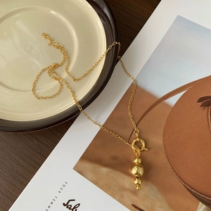 Detailed shot of 925 silver beaded gold necklace over a French fashion magazine