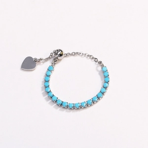 Detail of silver chain bracelet featuring sky blue round stones and a heart charm