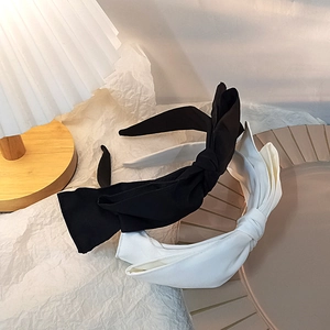Detail of chic double-layered bow headbands in black and white on a ceramic tray