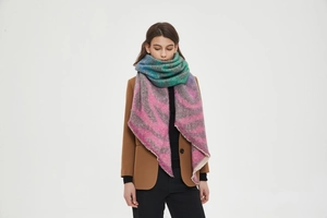 Detail of knit scarf with blue gradient and pink zebra pattern on a model attire