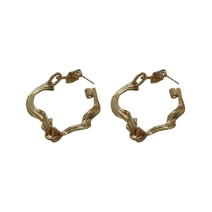 Minimalist gold geometric twisted hoop earrings with textured finish on white background