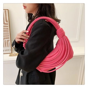 Detail of hot pink knotted shoulder bag with unique rope texture and crescent moon design