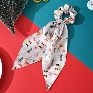 Detail of grey satin hair scrunchie with Christmas patterns on festive backdrop
