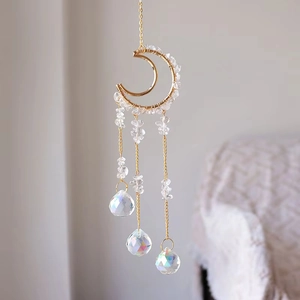 Detailed view of handmade moon suncatcher with crystal stones and hanging prism balls