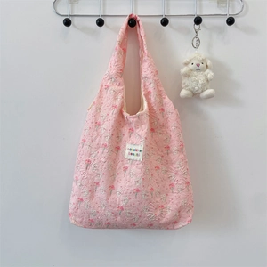 Pink quilted shoulder bag featuring floral textures and a cute white sheep plush charm