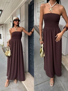 Detail of smocked waist and strapless bodice on a flowy dark brown maxi dress