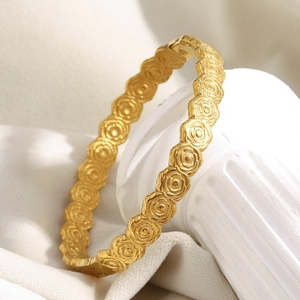 Dettaglio del bracciale in acciaio placcato oro 18 carati con motivi di rose a rilievo