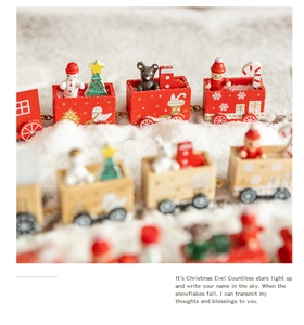 Detailed view of red and wood Christmas train ornaments with snowmen and trees on fake snow