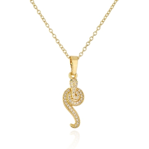 Macro detail of gold snake pendant with cubic zirconia and green gem accents