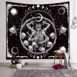 Dark aesthetic black tapestry with moon phases and skull patterns on a white brick wall