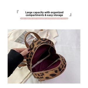 Detail of leopard print mini backpack showing spacious purple lining and inner pocket