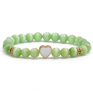 Light green cat eye beaded bracelet with a white heart charm and gold-plated details