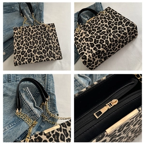 Close-up of leopard print handbag showing golden chain details and leather handle texture