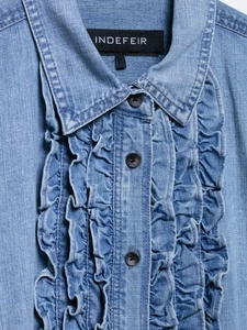 Detail of blue denim shirt showing ruffled edges and dark gray buttons close-up