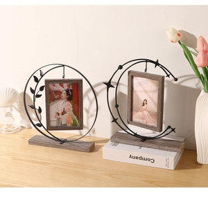 Detail of luxury vintage iron moon picture frames with leaf and star accents on wood base