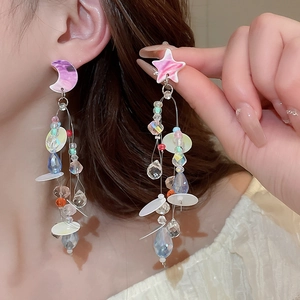 Detail of star and moon tassel earrings with colorful crystals and gradient sequins