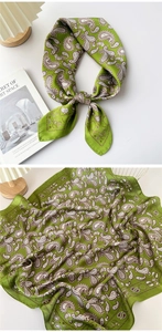 Detailed view of green paisley silk scarf with satin finish and elegant draped texture